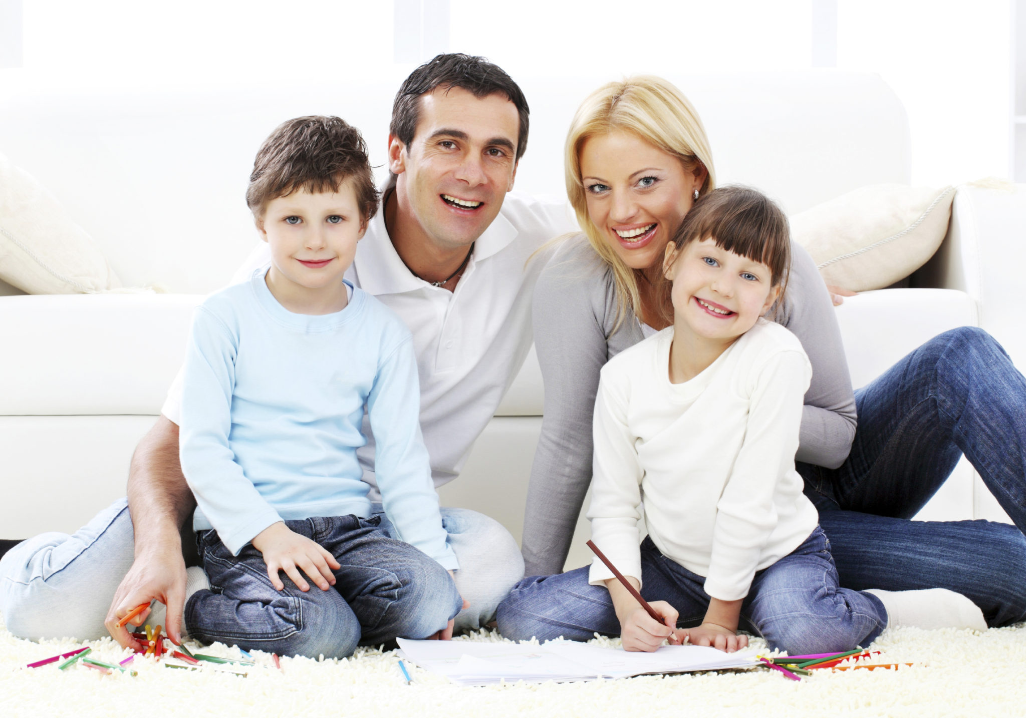 Portrait of a parent with children drawing in colorful pencils.on the carpet
